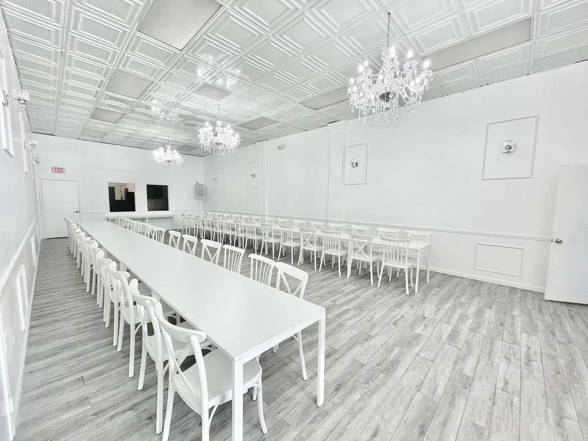 Blanco Event Center empty all-white venue space with chandeliers